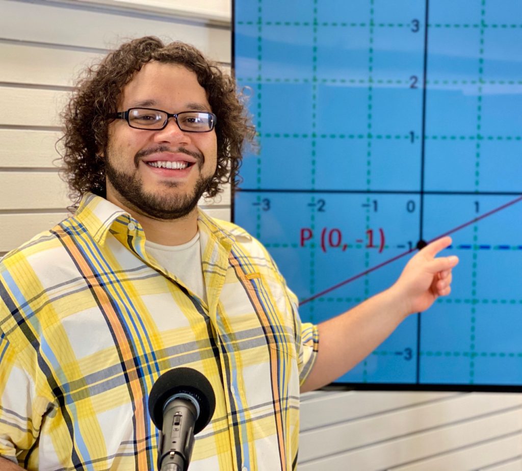 A man pointing to a graph on the wall