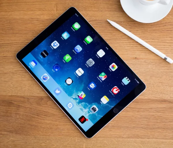 A tablet sitting on top of a wooden table.