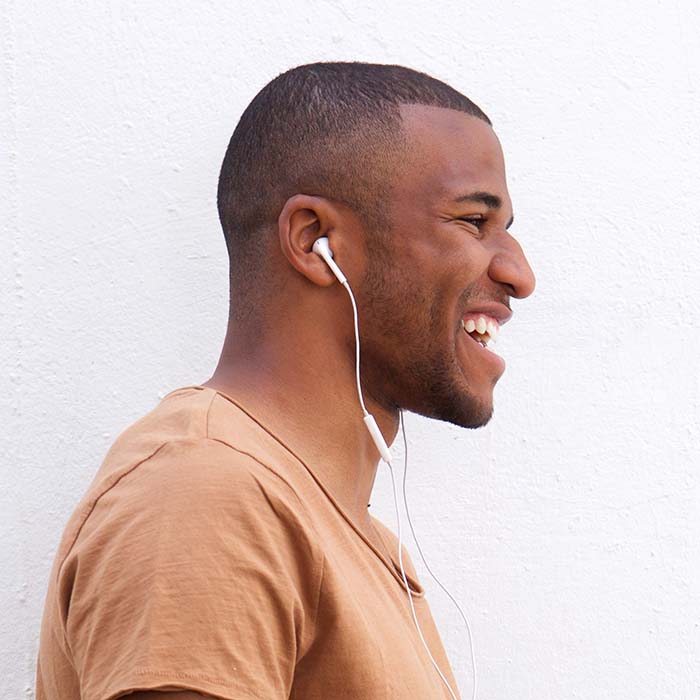 A man with headphones on smiling for the camera.
