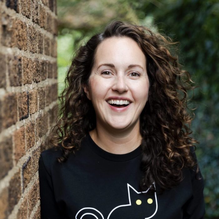 A woman with curly hair and a cat shirt.